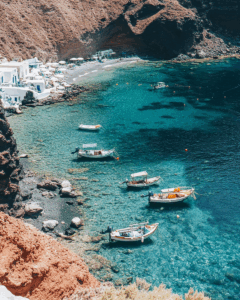 Crystal-clear beach with boats, perfect for passive income for travel, funding a digital nomad lifestyle in 2025